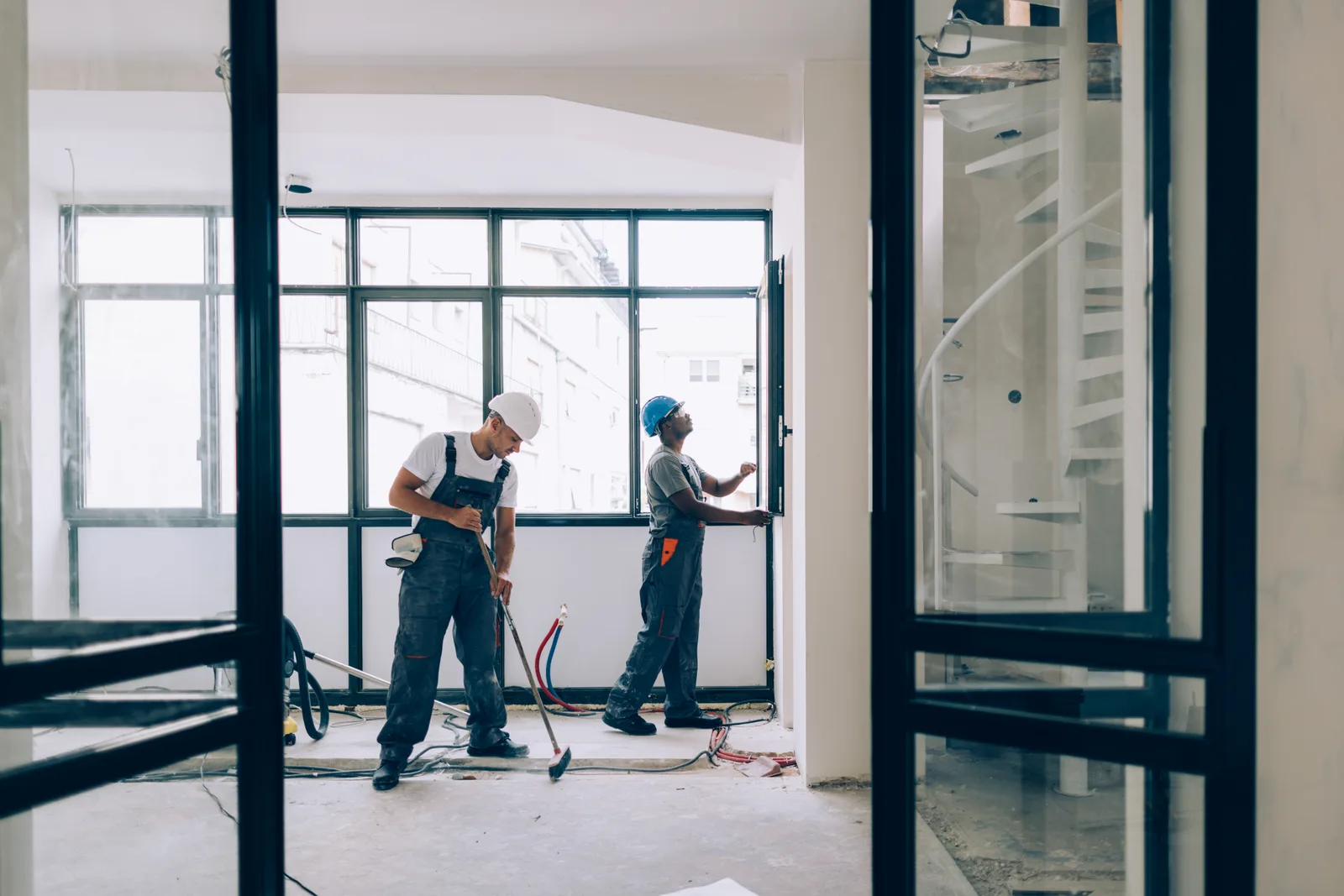 Crew completing interior work behind steel-framed glazing