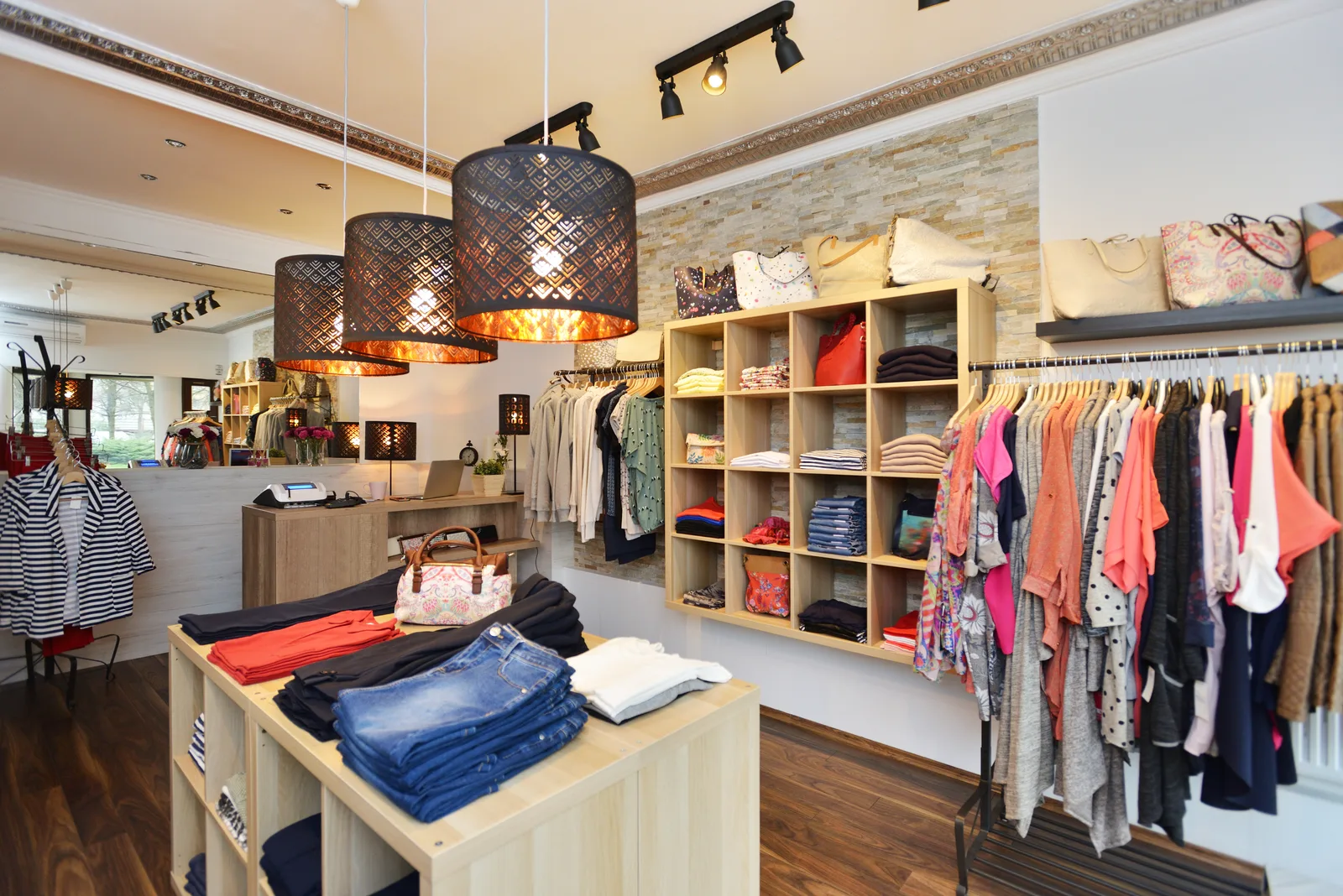 Boutique interior with stone feature wall, display shelving and track lighting