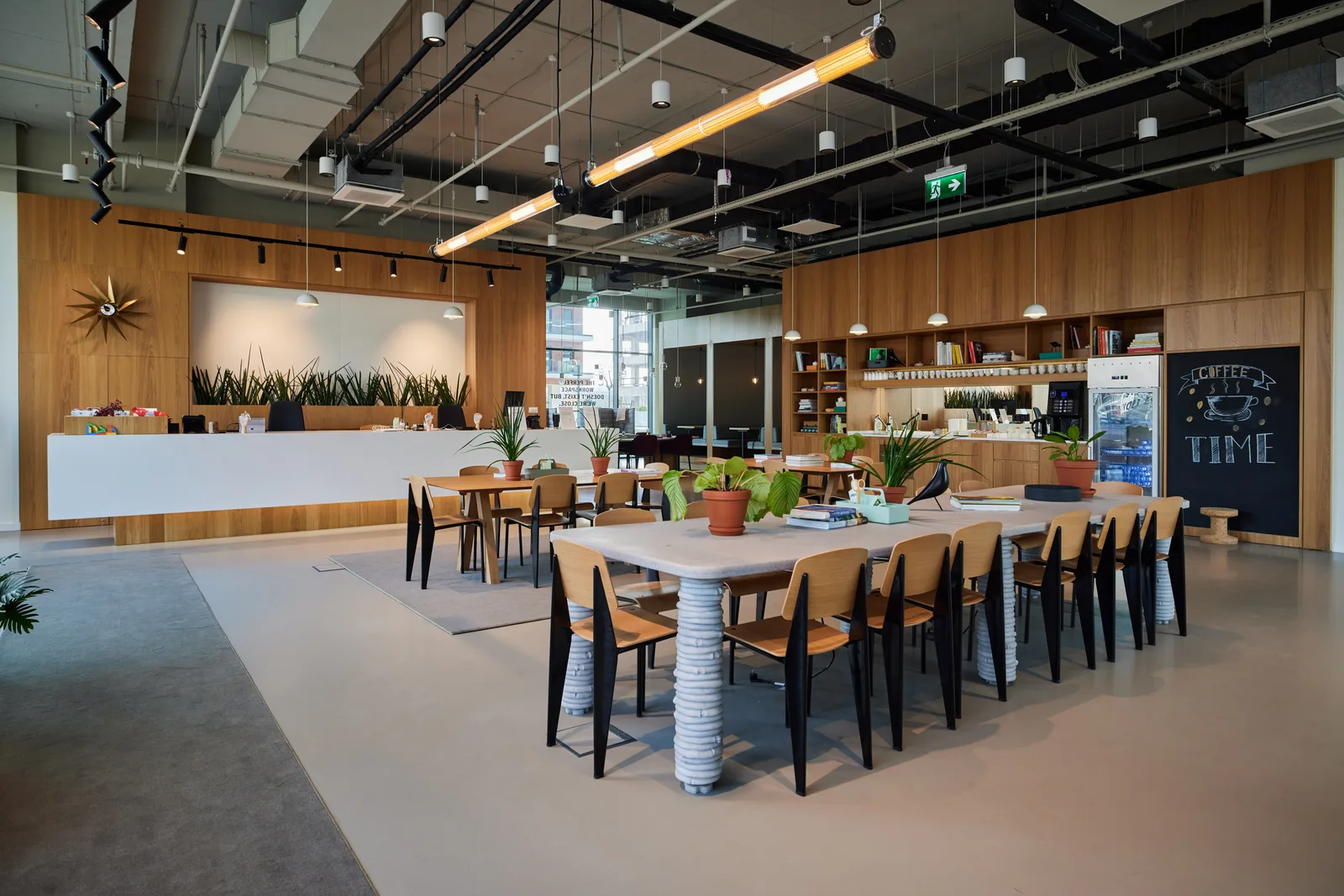 Renovated workplace lounge and café with wood panelling and communal tables