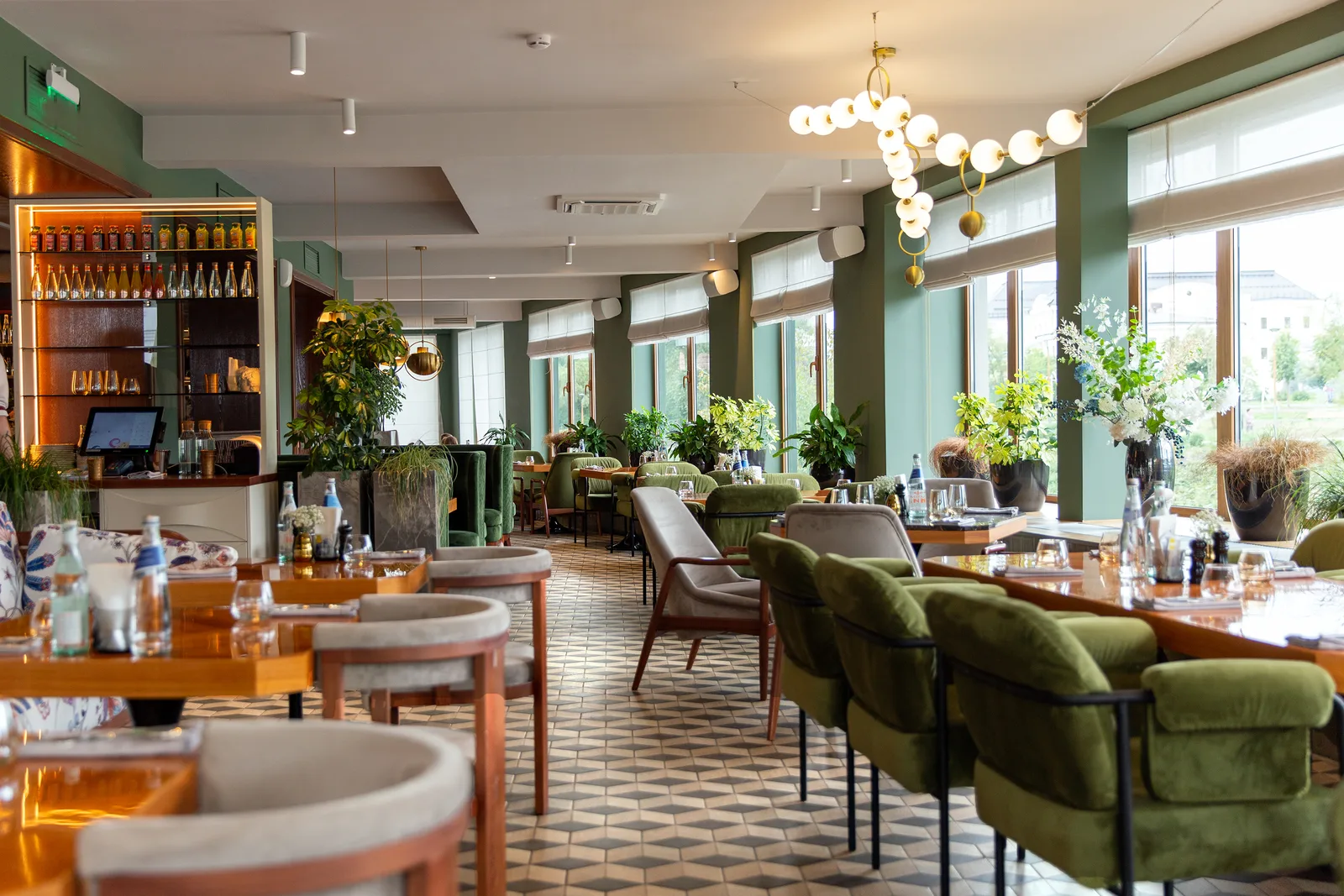 Renovated restaurant dining room with green banquettes and warm lighting