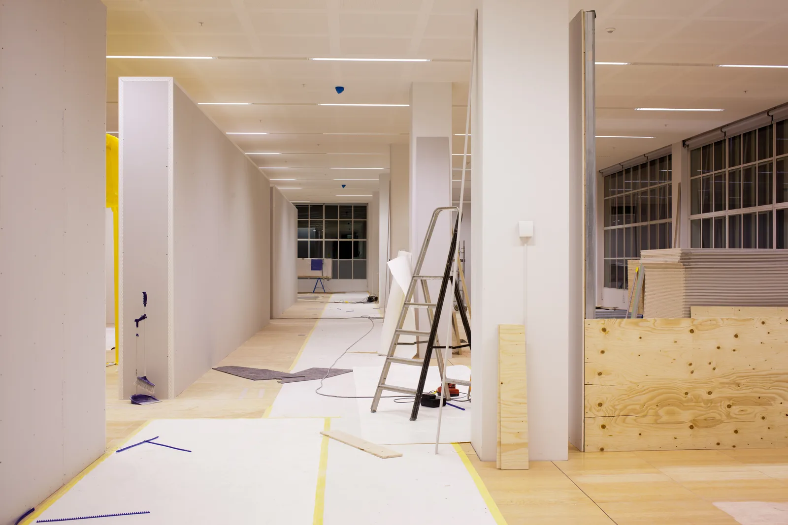 Commercial office renovation in progress with protective floor coverings and new partition walls