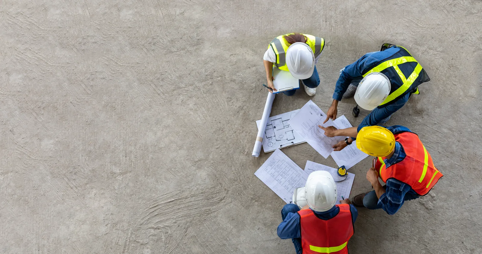 Renovation plans and drawings spread across a table during a design-build review